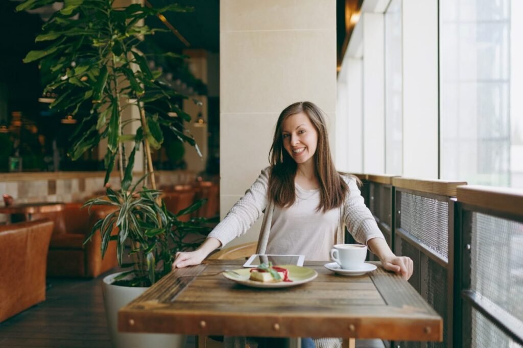 A solo traveler enjoying a relaxed meal by a cafe window