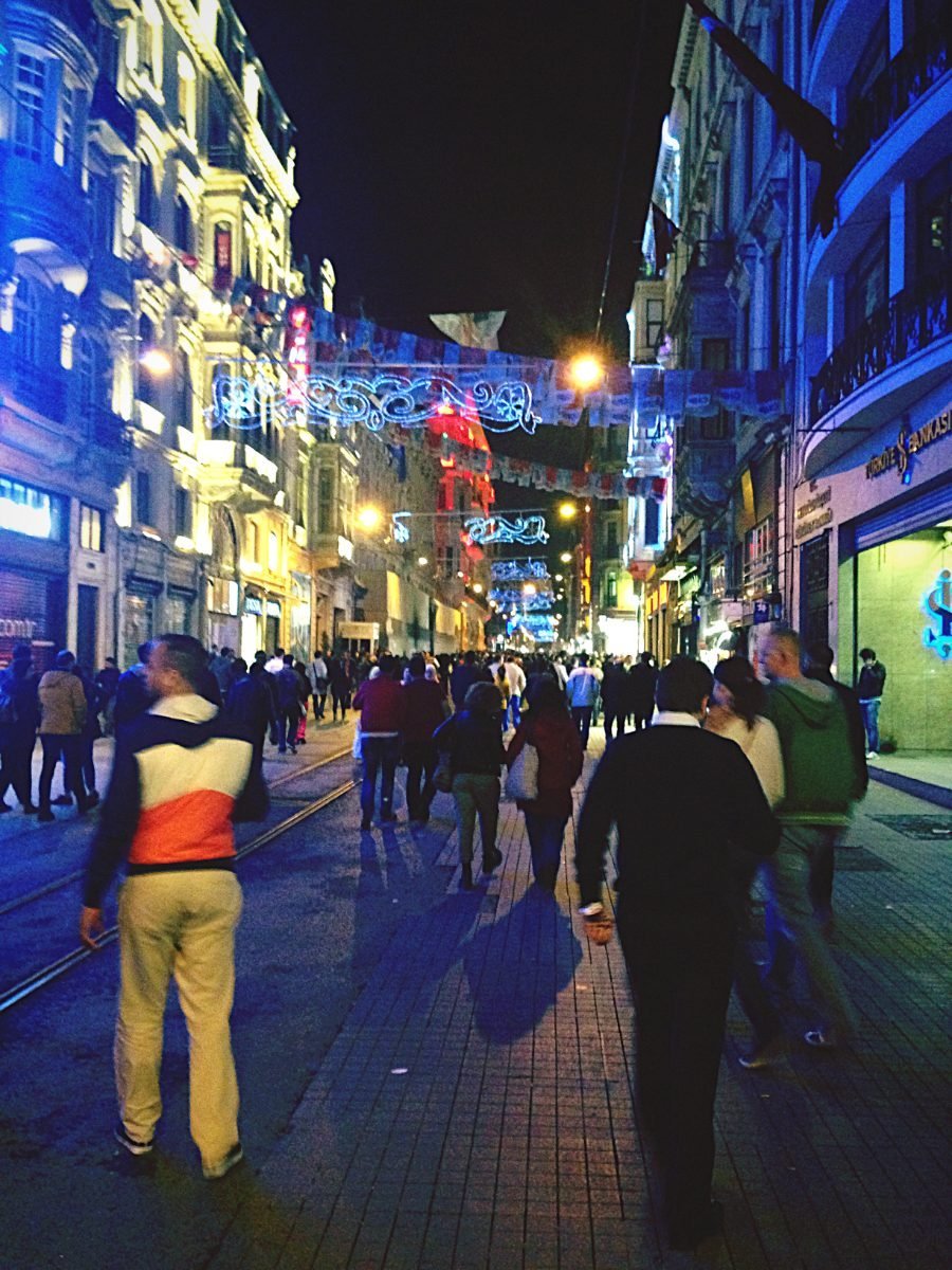 People walking on a lively illuminated street at night