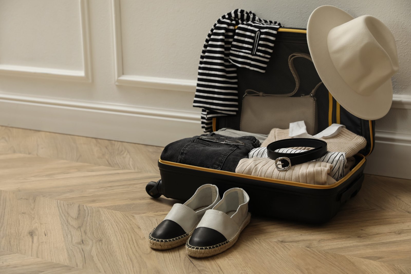 Open suitcase with folded clothes and accessories
