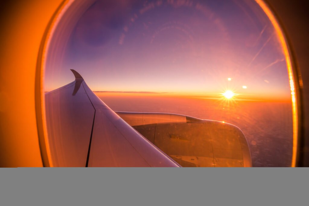 Sunset view through an aircraft window and wing