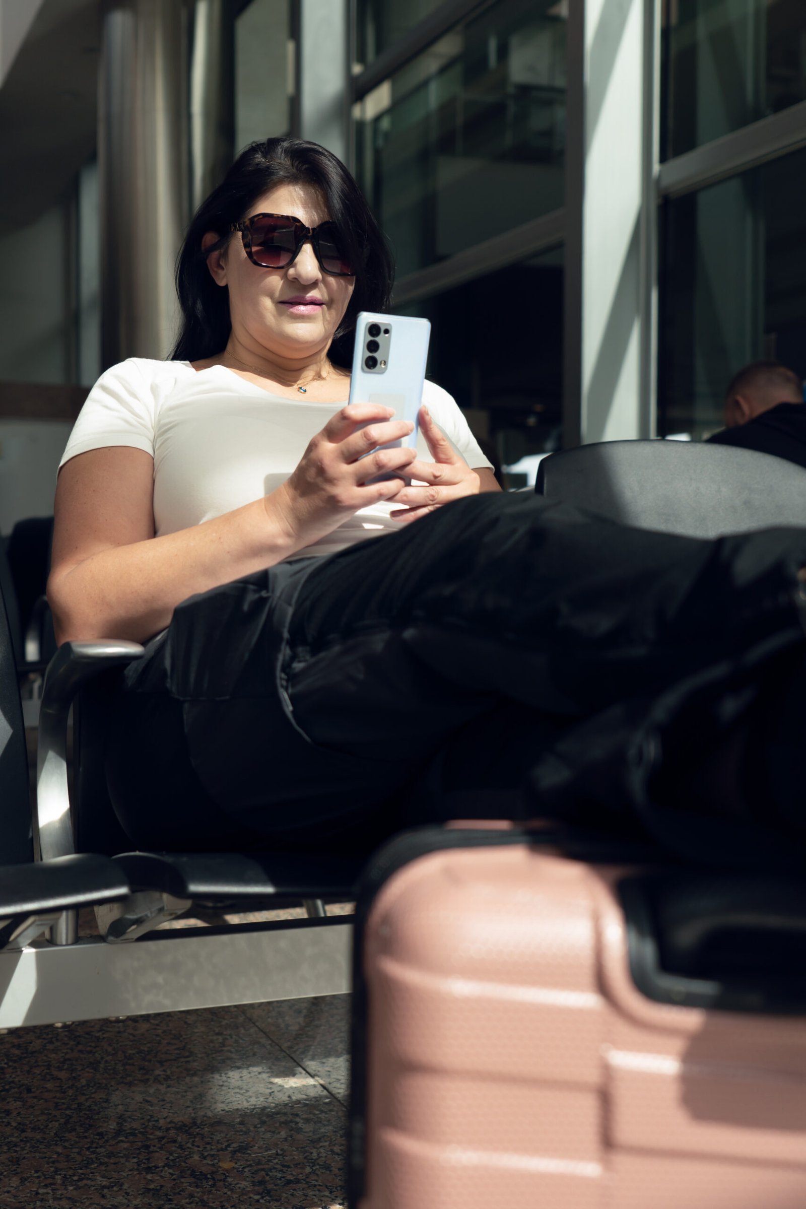 Female traveler checking a smartphone while waiting at the airport