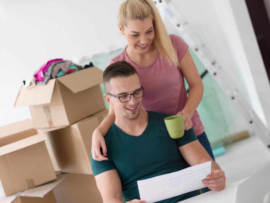 A young couple planning their move to a new home with boxes around them