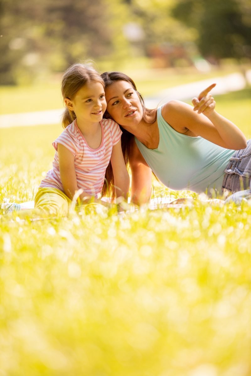 A mother and daughter enjoying a park on a sunny day