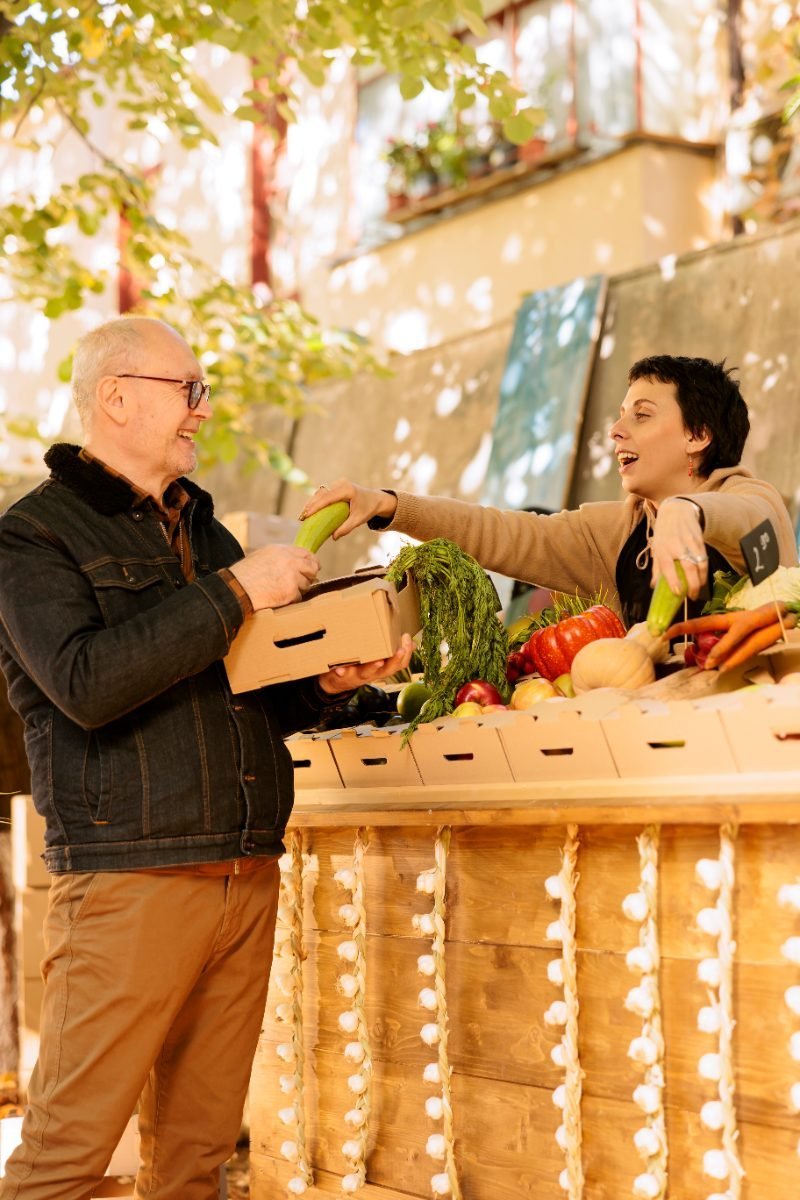 A market vendor chatting with a customer