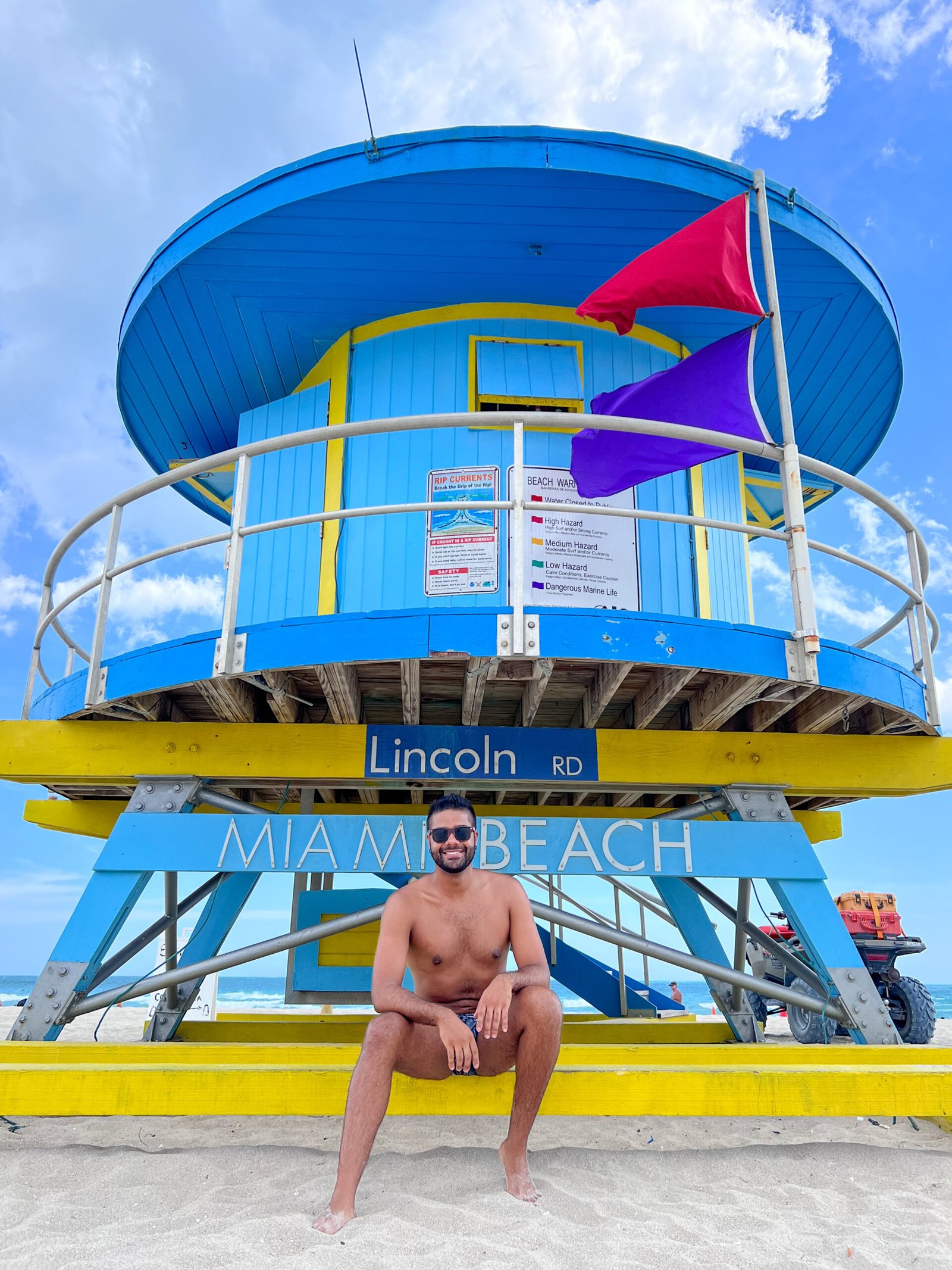 Tourist sitting at a blue lifeguard house on Miami Beach