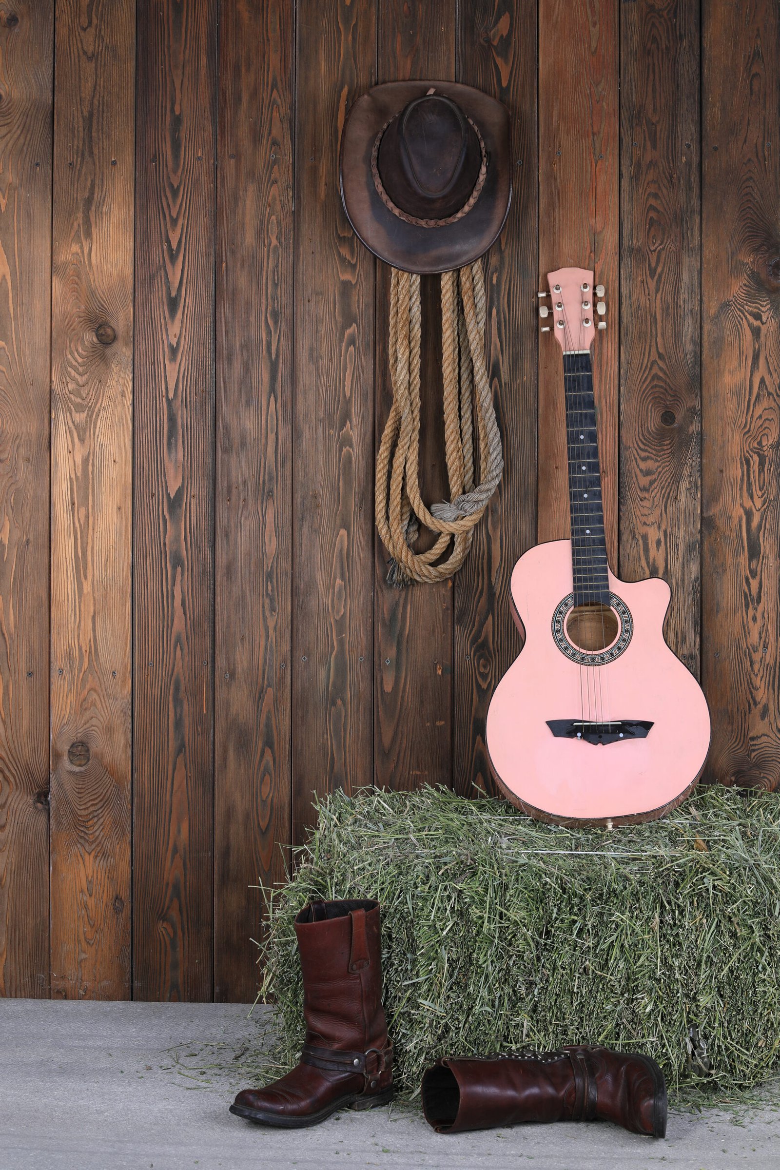 Acoustic guitar and cowboy boots in a Nashville barn setting