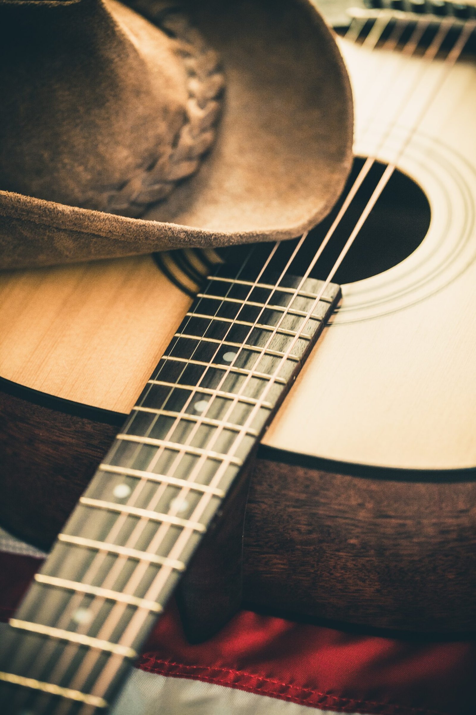 Acoustic guitar and cowboy hat with American flag background