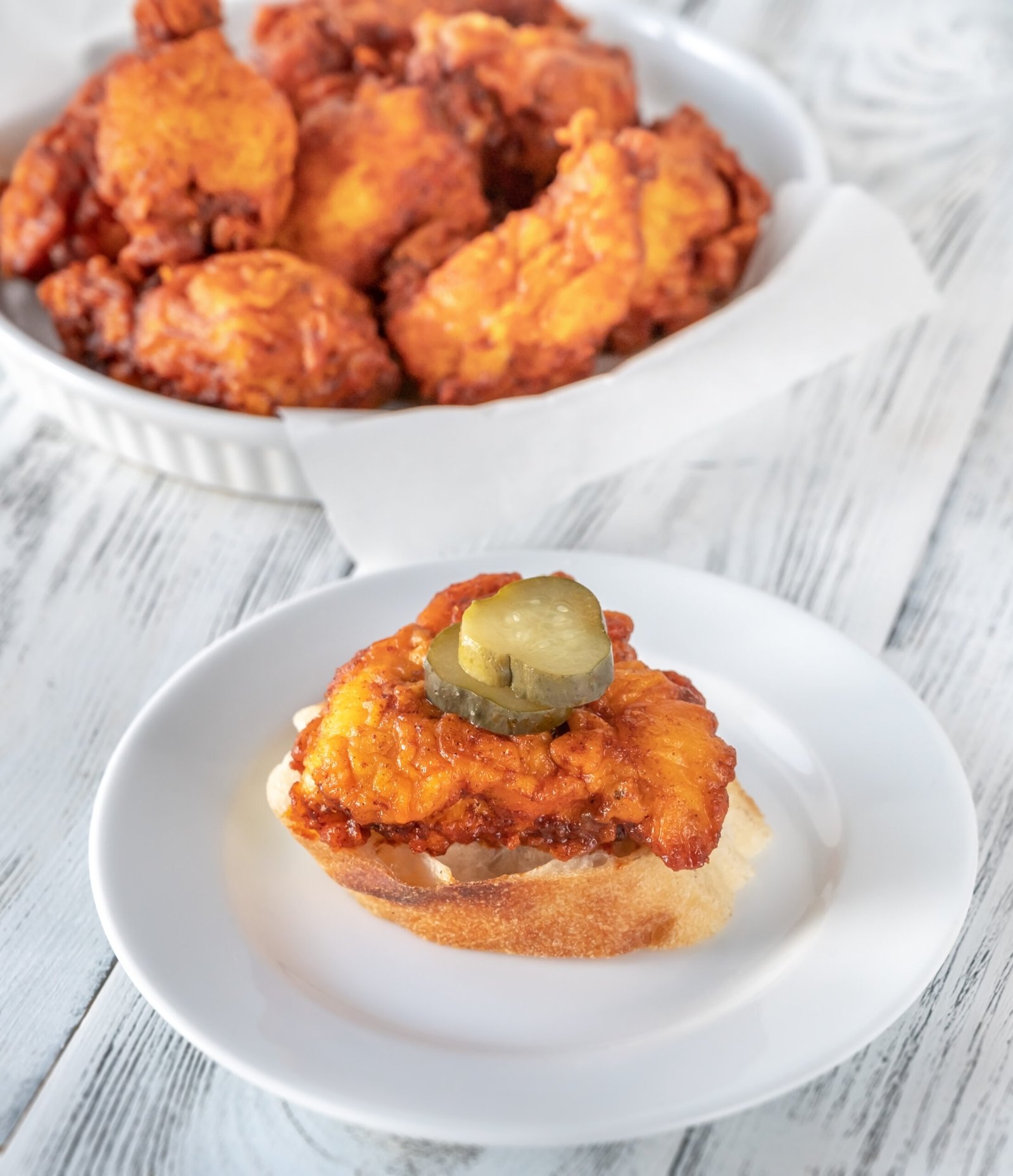 Plate of Nashville hot chicken covered in cayenne pepper sauce