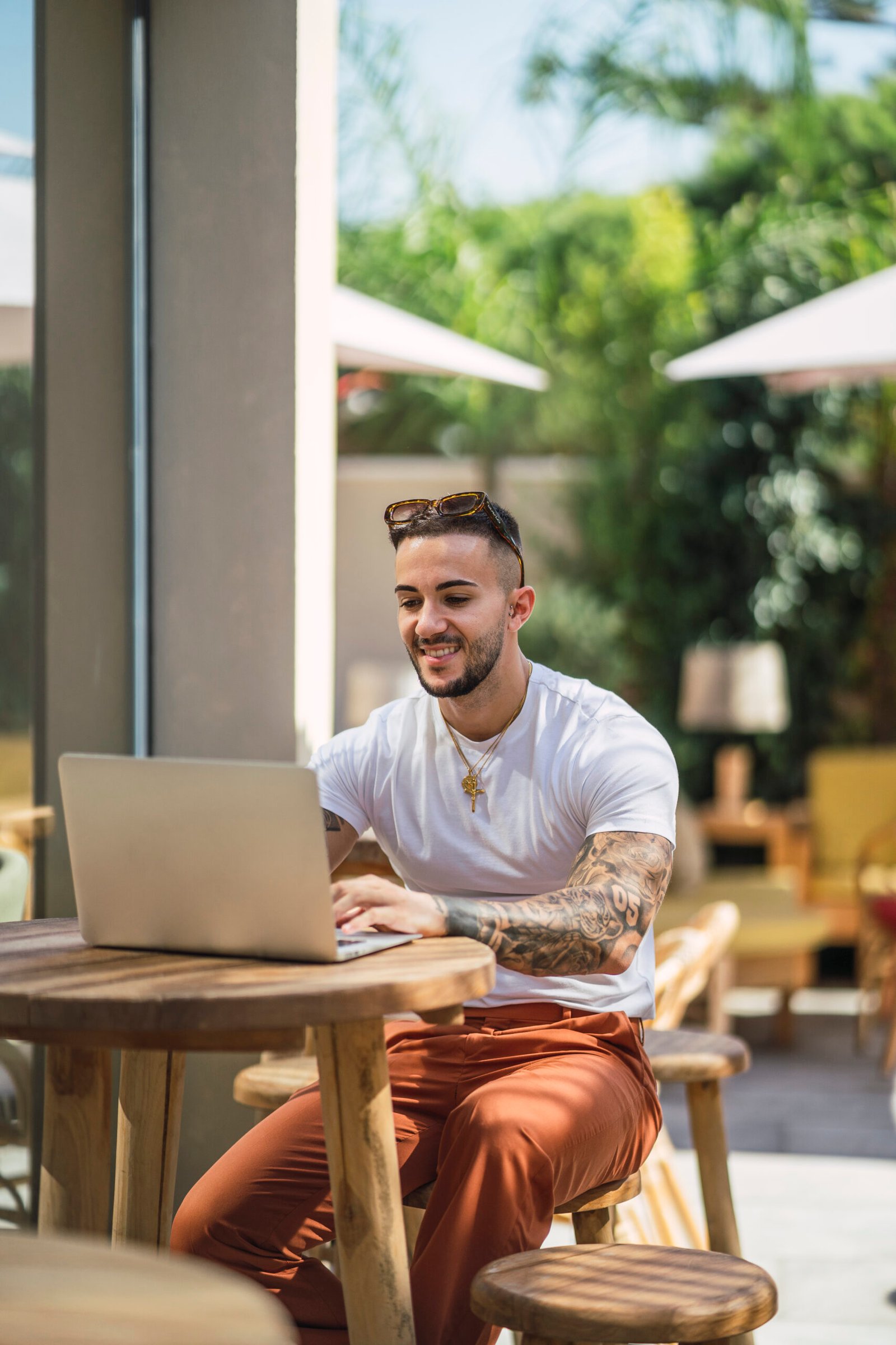 Young man working with a laptop from an outdoor cafe in Spain