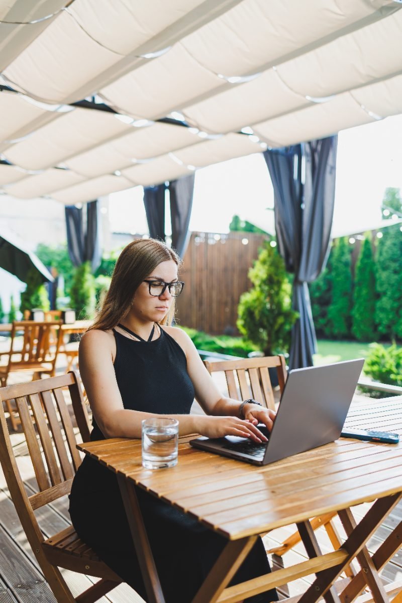 Remote worker on a cafe terrace with a laptop