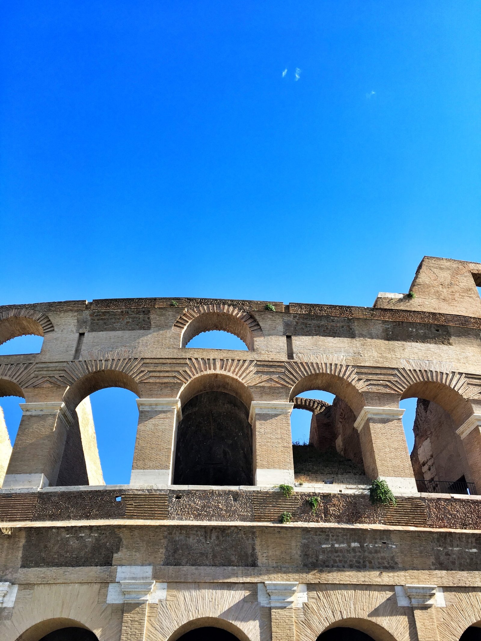 Low angle view of the Colosseum against a clear blue sky