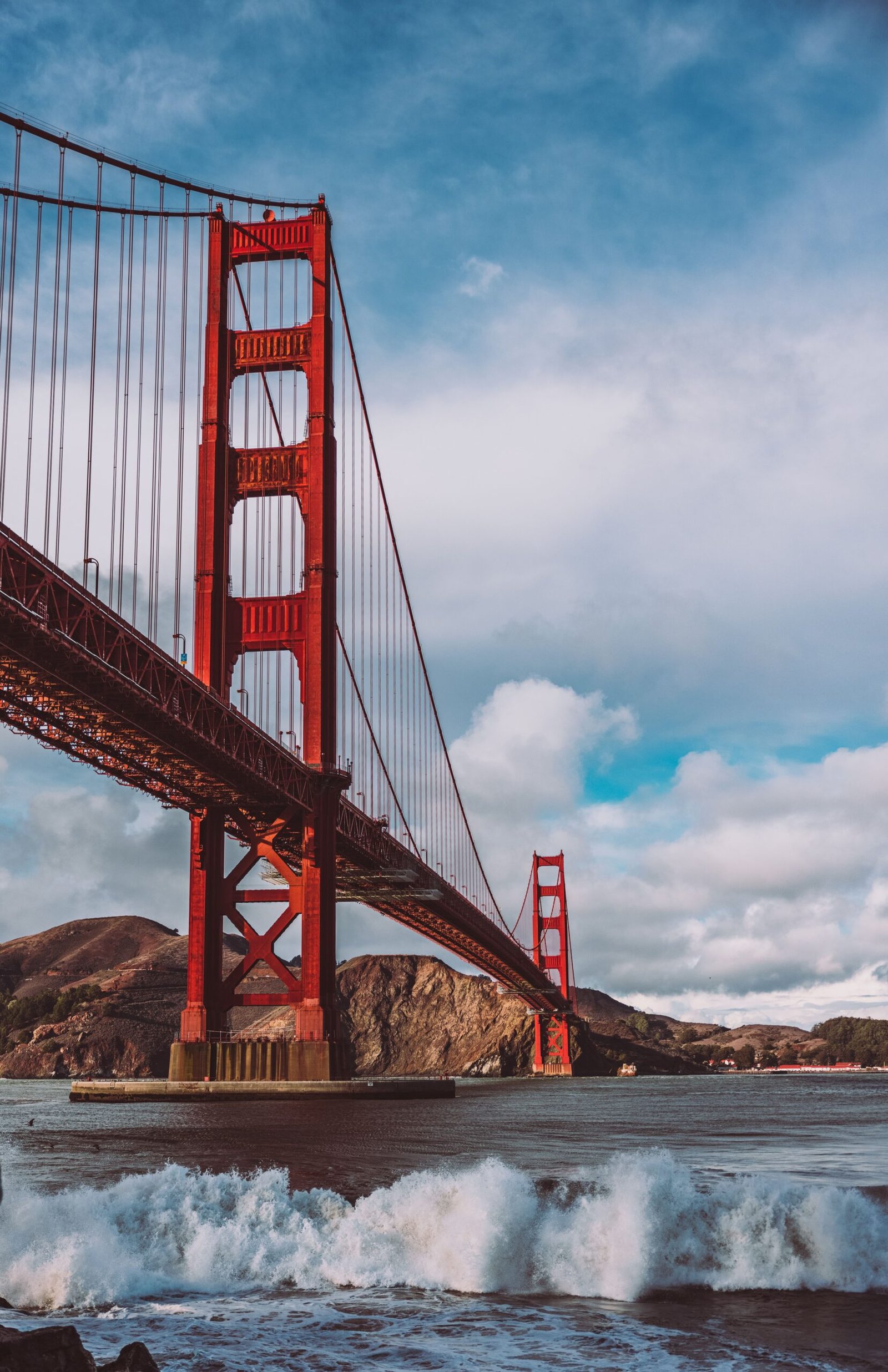 Vertical shot of the Golden Gate Bridge with splashing waves