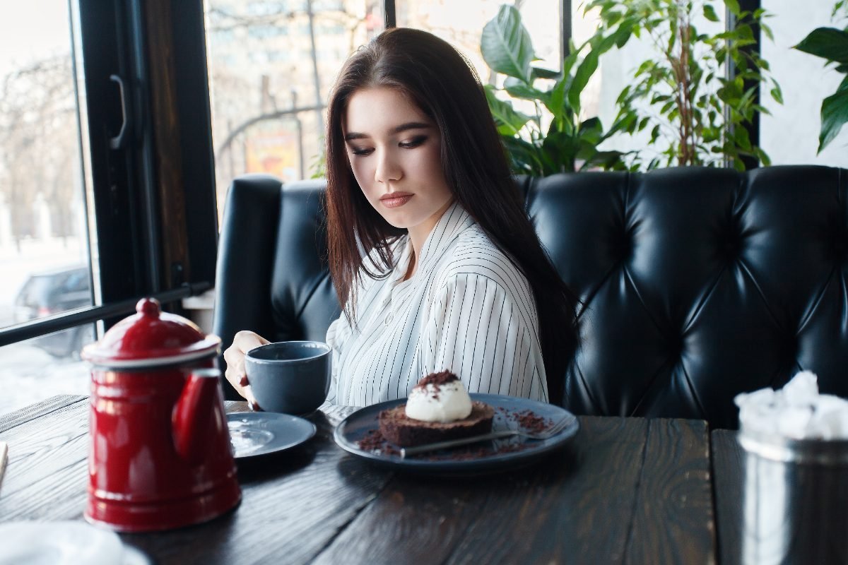 A solo traveler reading while waiting for her meal