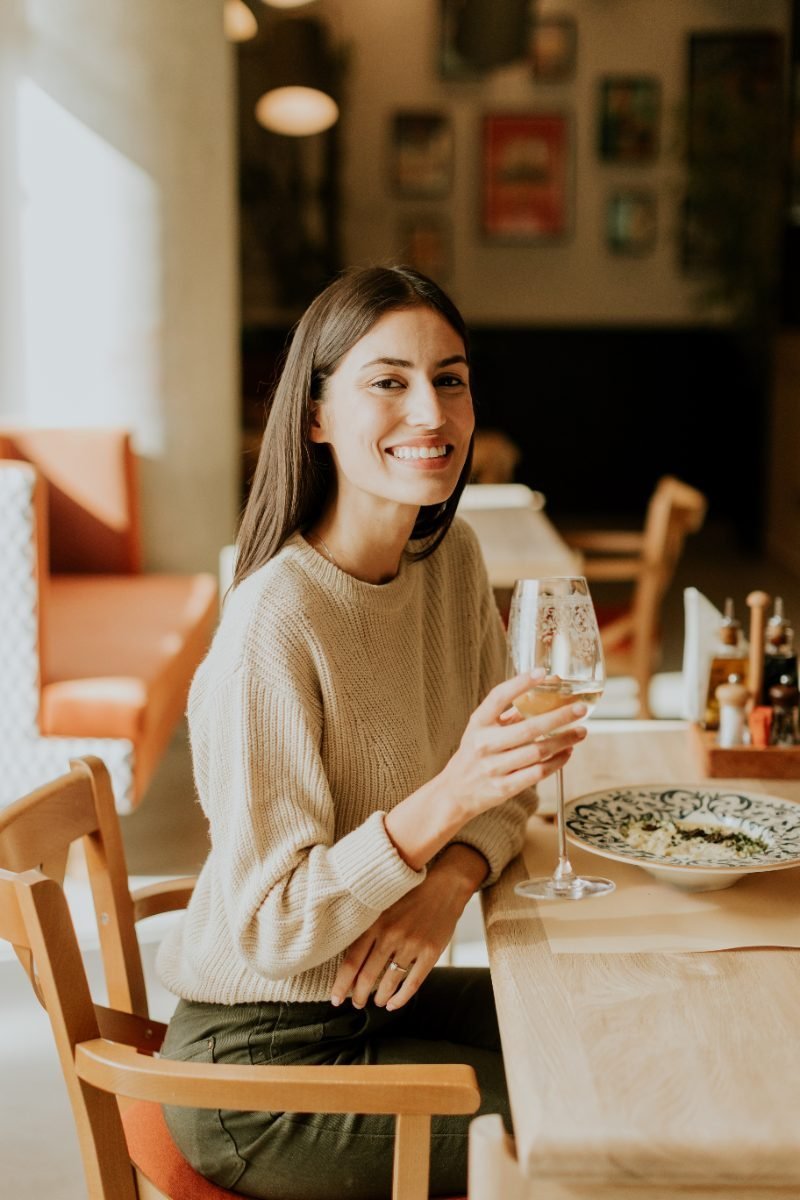 A solo traveler enjoying dinner and a glass of wine