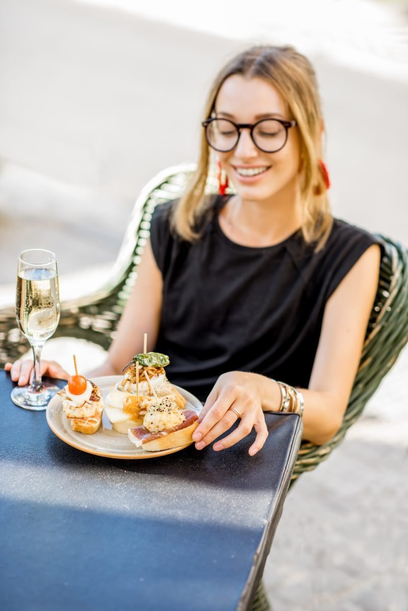 A solo traveler enjoying tapas at a bar counter