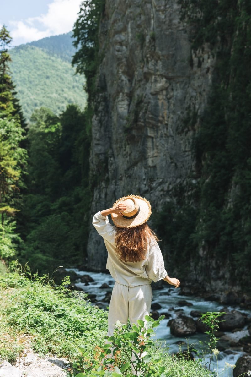 A solo female traveler at a mountain river