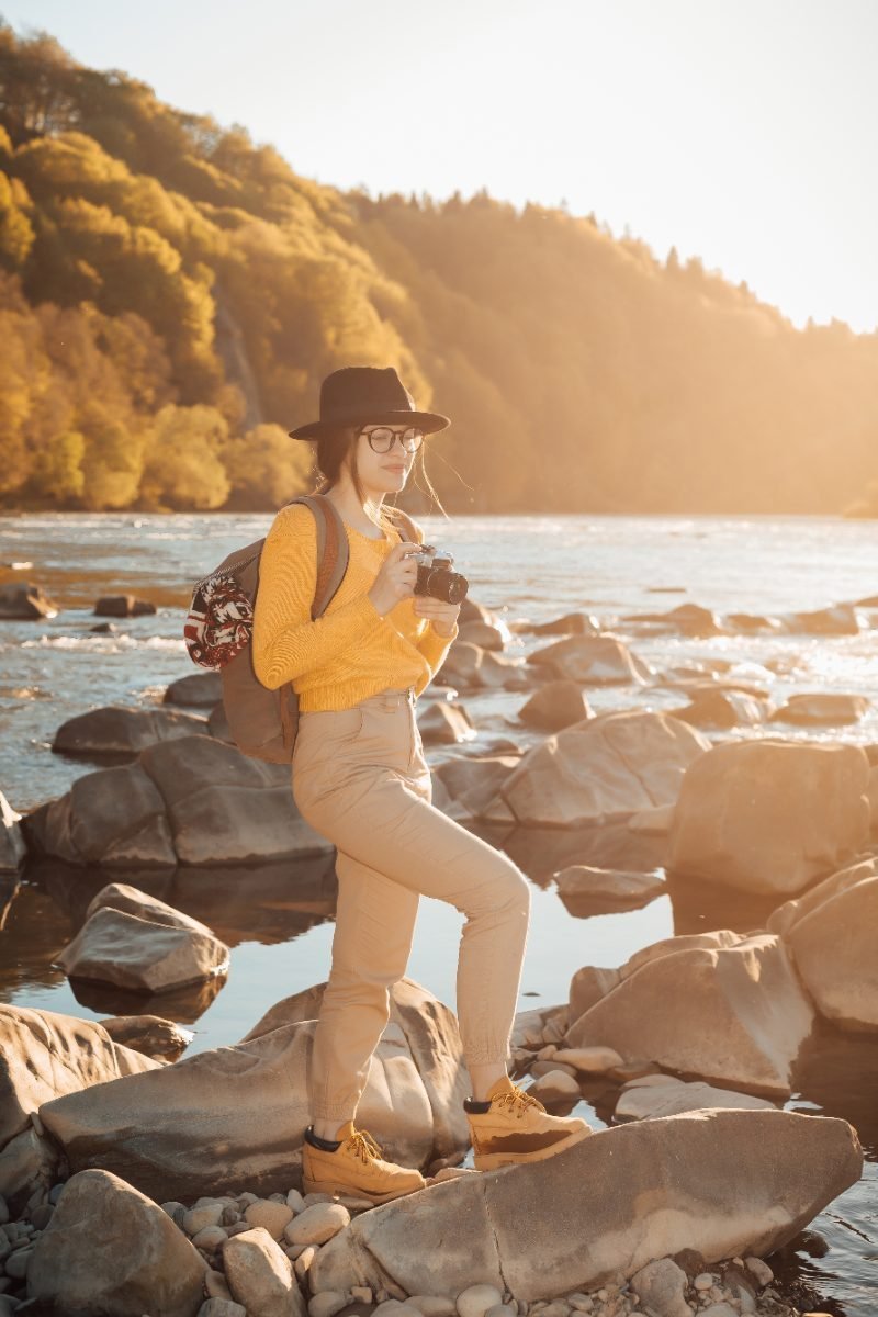 A solo female traveler photographing a scenic view