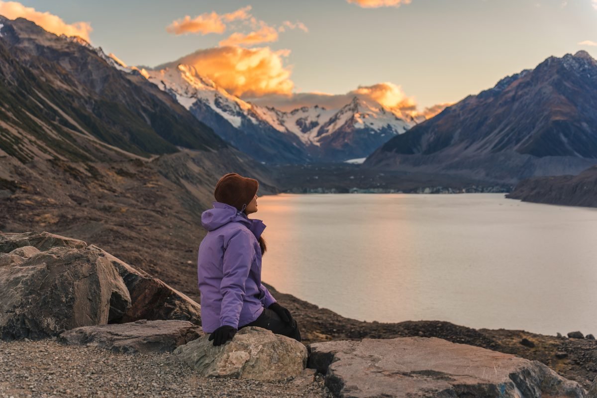 A solo traveler admiring a lake in New Zealand
