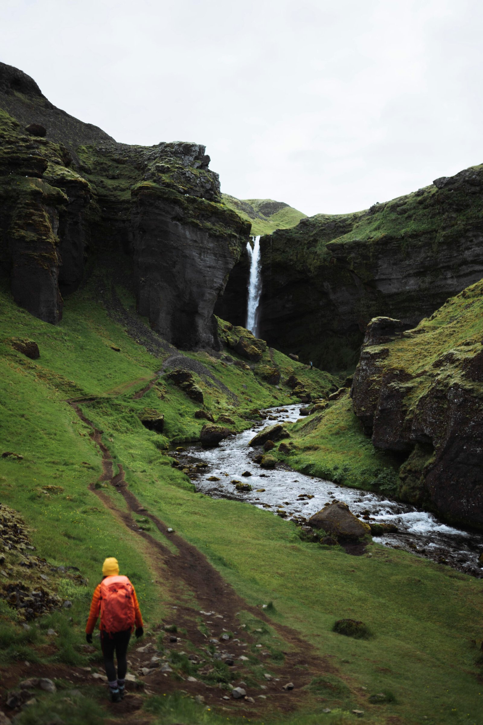 Female hiker admiring Kvernufoss waterfall alone in South Iceland