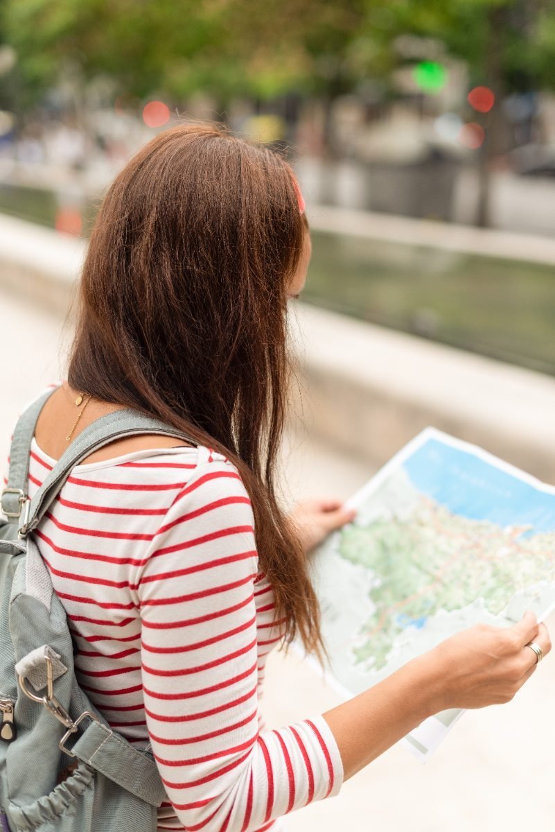 A solo traveler navigating a city with a map