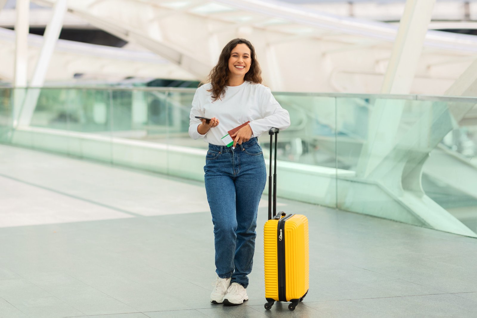 Confident solo woman traveler with suitcase at airport