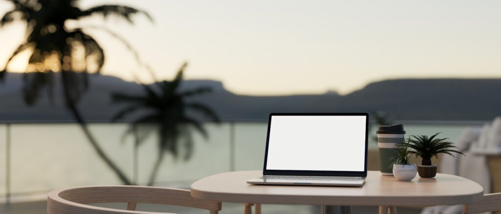 Laptop on a terrace table with an ocean view, digital nomad working remotely