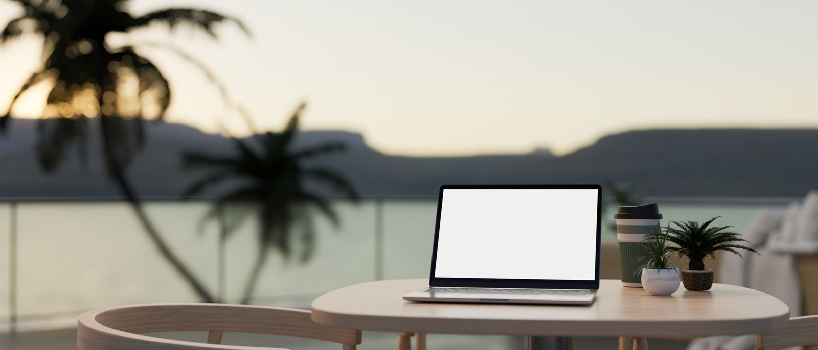 Laptop on a terrace table with an ocean view, digital nomad working remotely