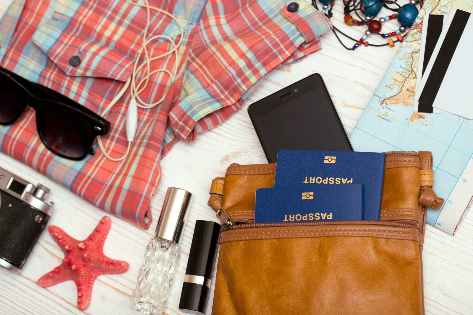 Flat lay of passport, phone, documents, and travel essentials for a move abroad