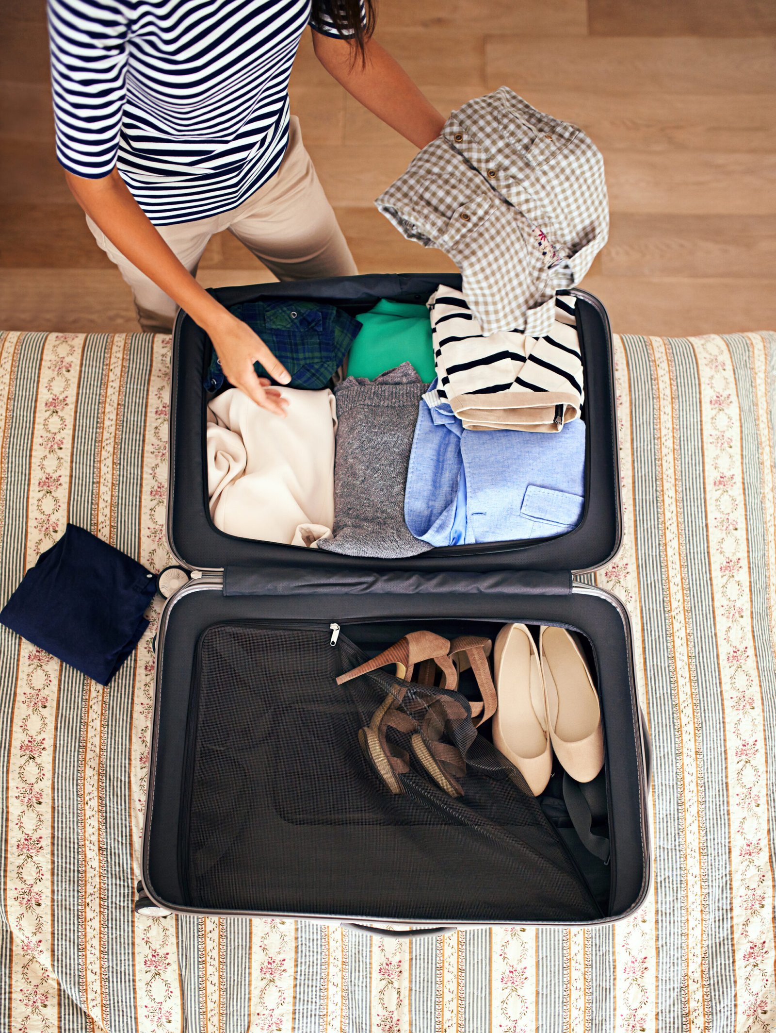 Woman packing a suitcase on a bed
