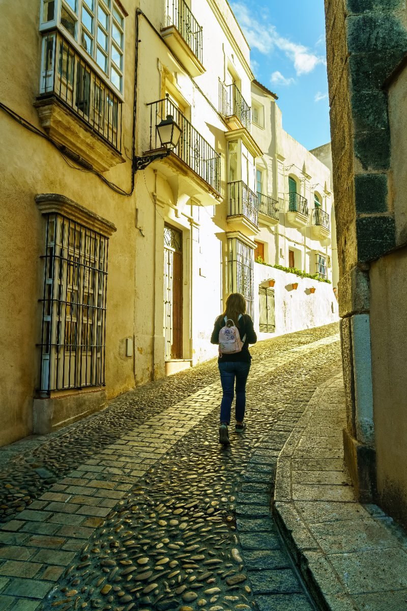 Wandering a sunlit old-town street in Spain