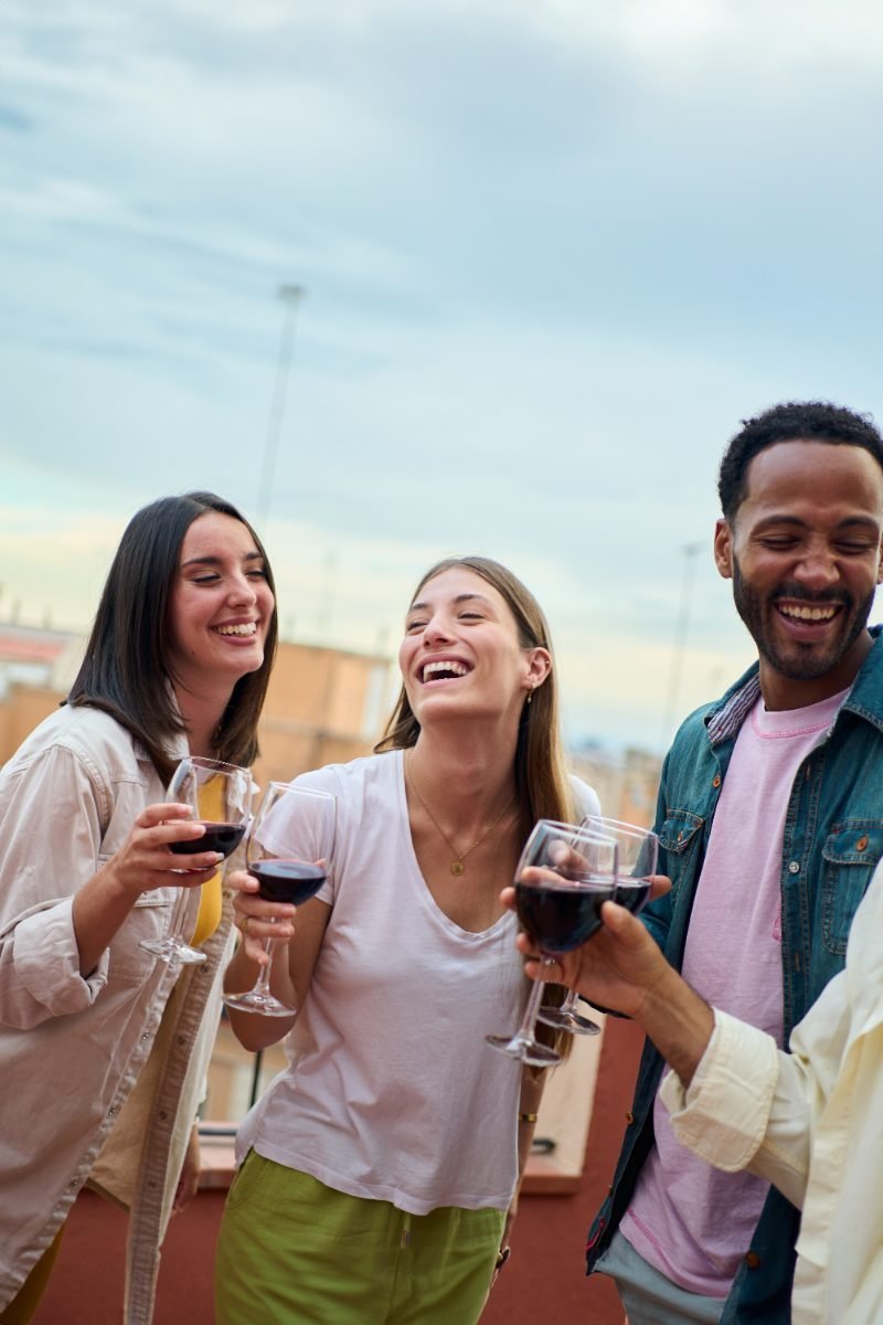 Friends laughing over drinks on a summer evening
