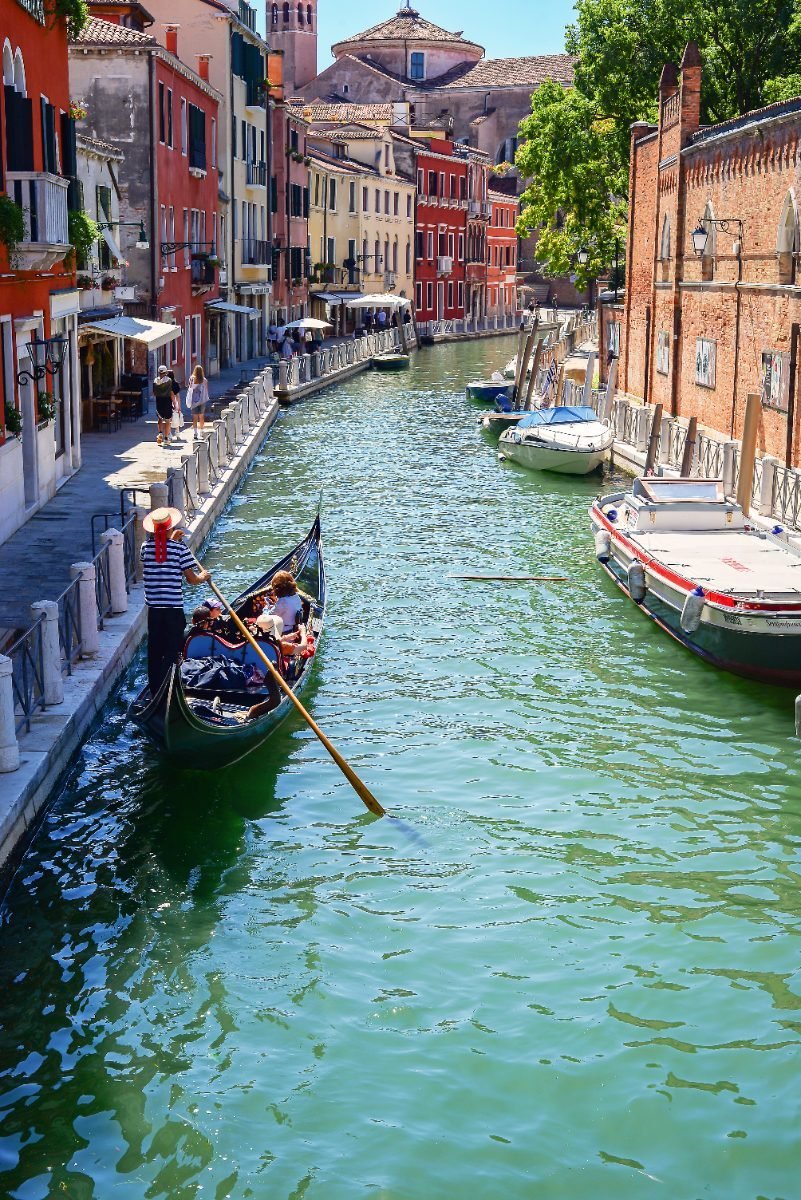 A gondola floating down a small Venice waterway