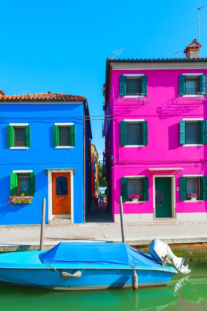 Blue and pink houses on a canal in Burano, Venice