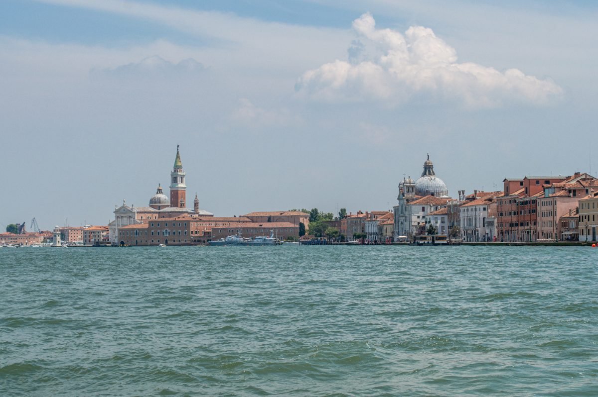 Venice canal embankment with boats and old houses