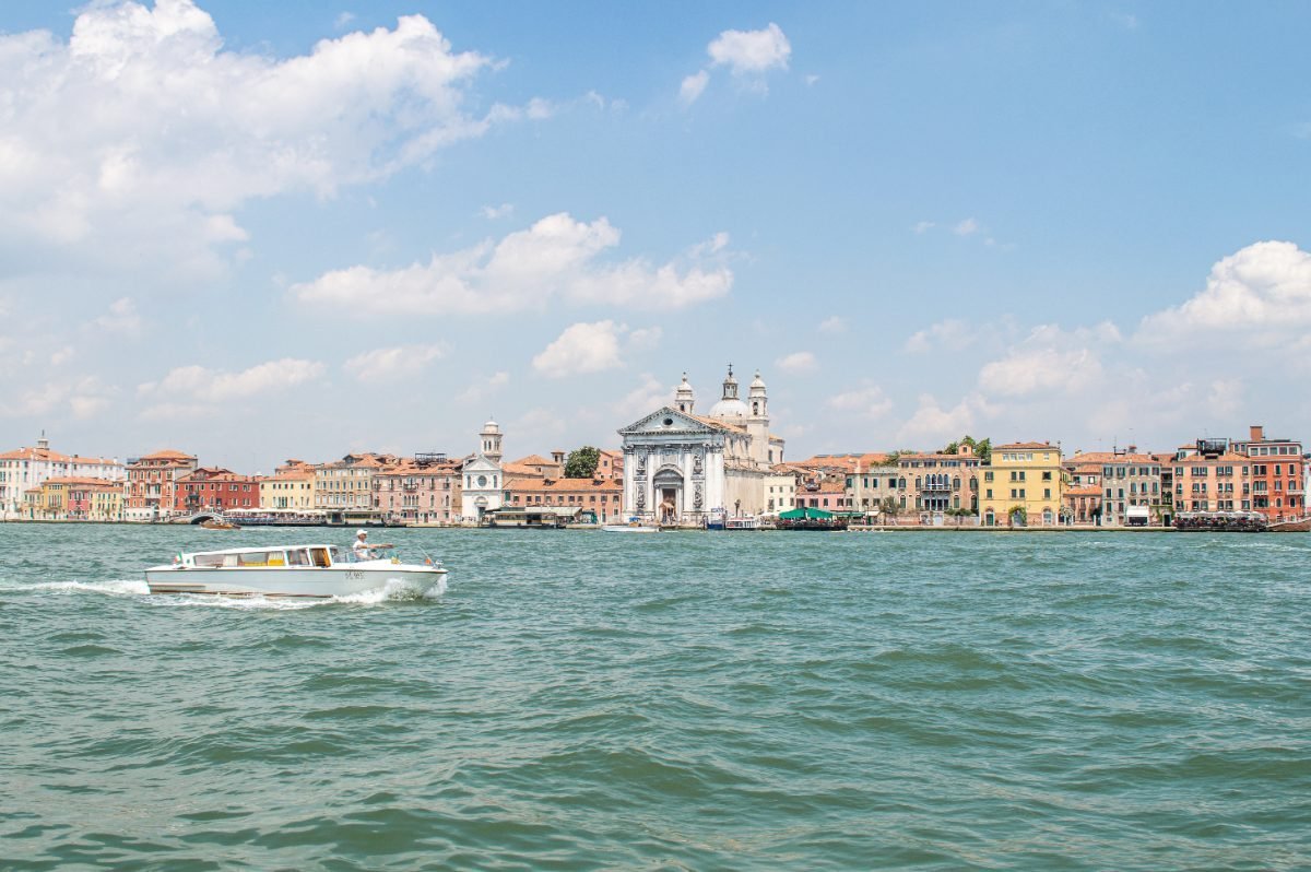Venice canal embankment with boats and old houses