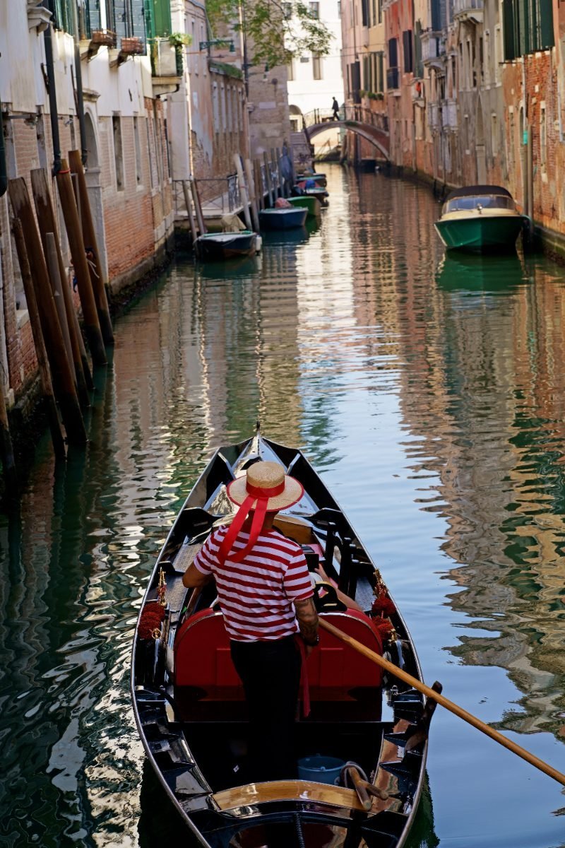 Gondolier with tourists on a Venice canal