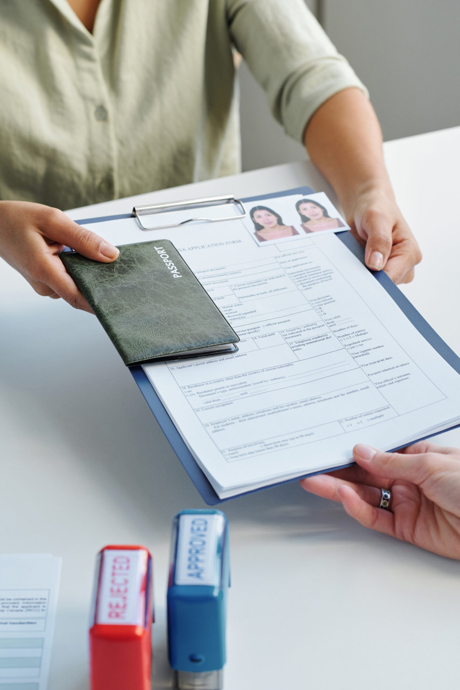 A woman submitting visa application documents at a consulate
