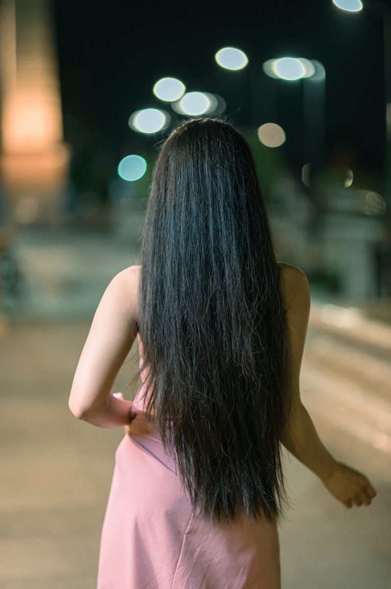 A woman walking alone at night on a well-lit city street