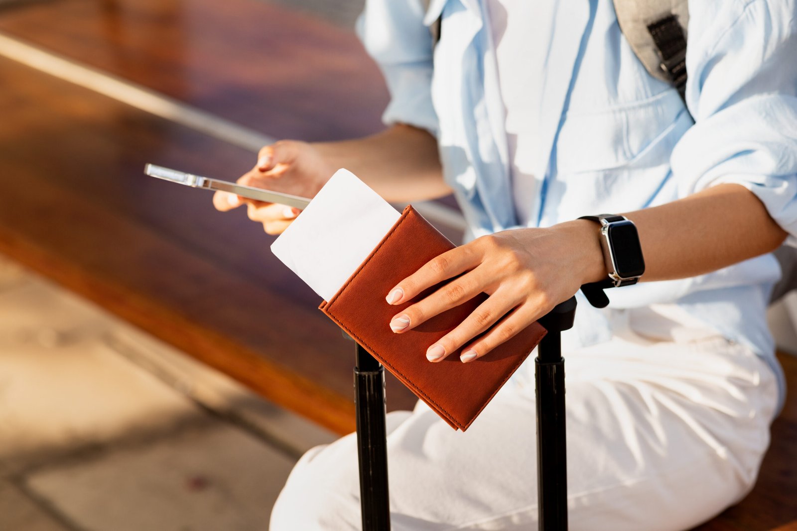 Woman with passport and documents waiting for transport
