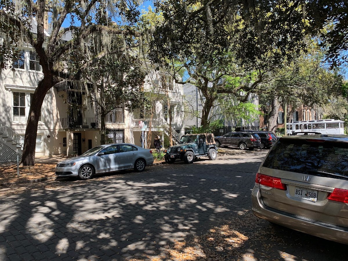 A historic residential street in Savannah lined with old townhouses