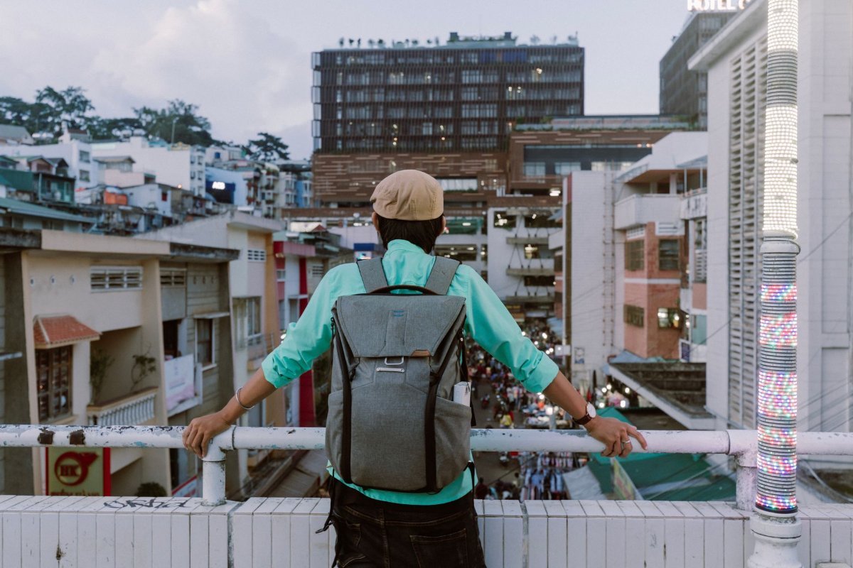 A traveller with a backpack looking out over a busy street