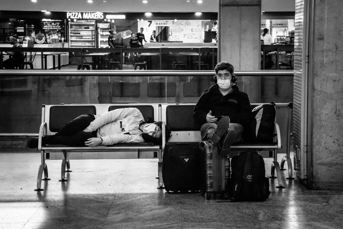A traveller resting on a bench in an airport