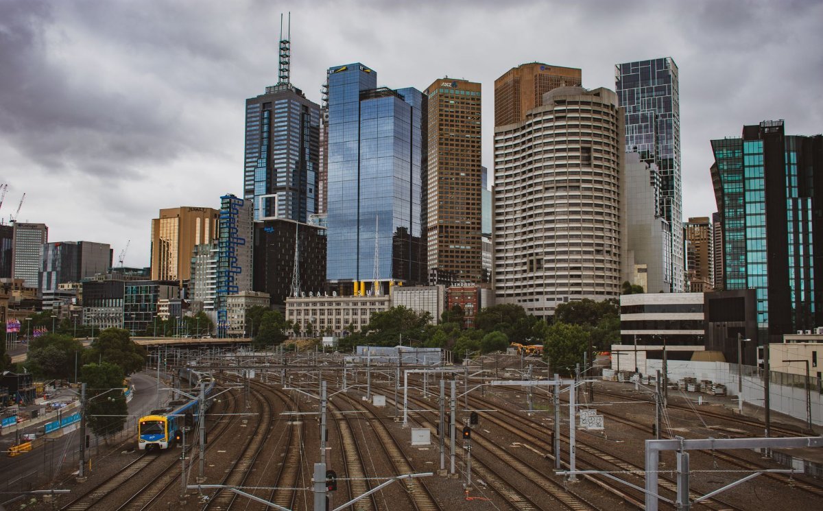 A city skyline with railway tracks leading in