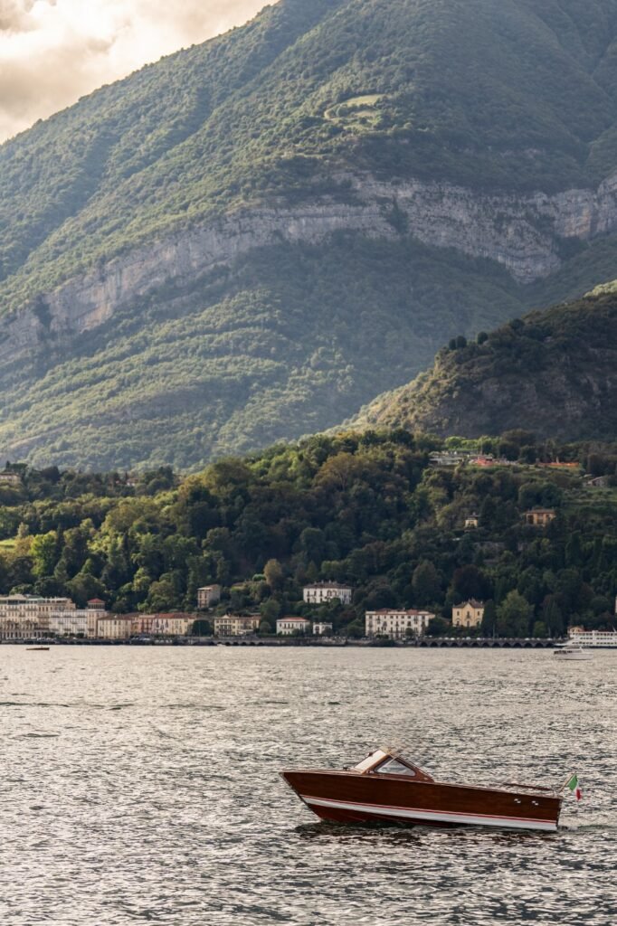 A boat on Lake Como with the village and mountains behind