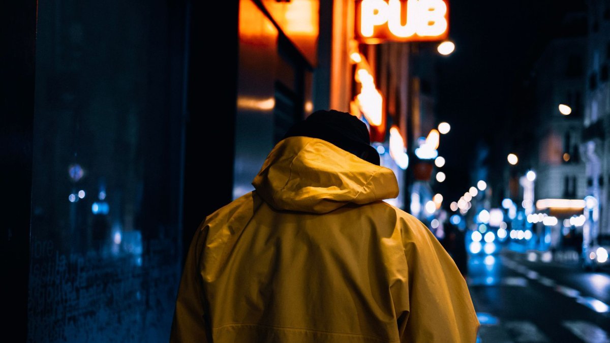 Walking alone through a city street in the evening