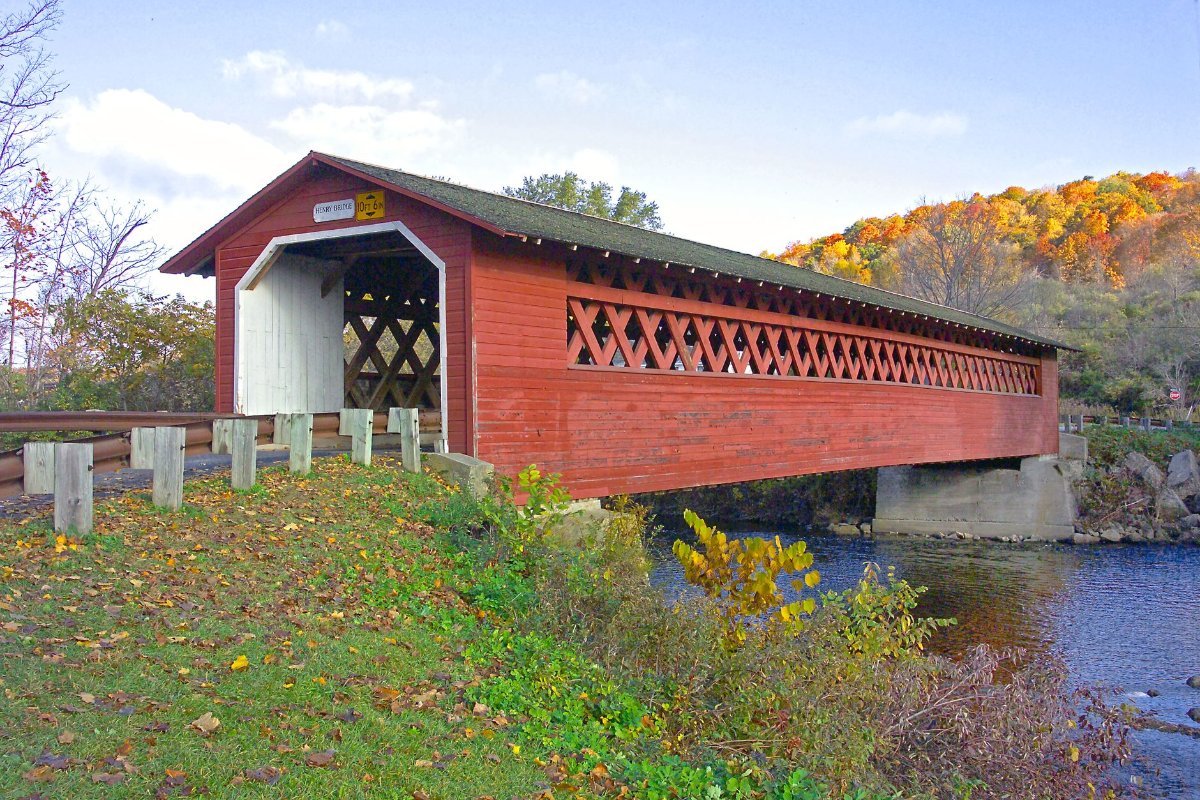 A wooden covered bridge over a Vermont river in autumn