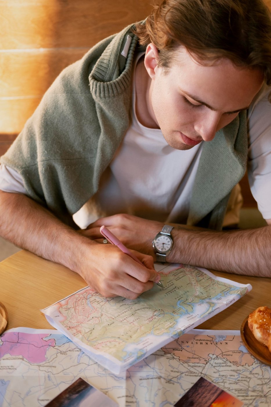 A traveller writing notes on a paper map