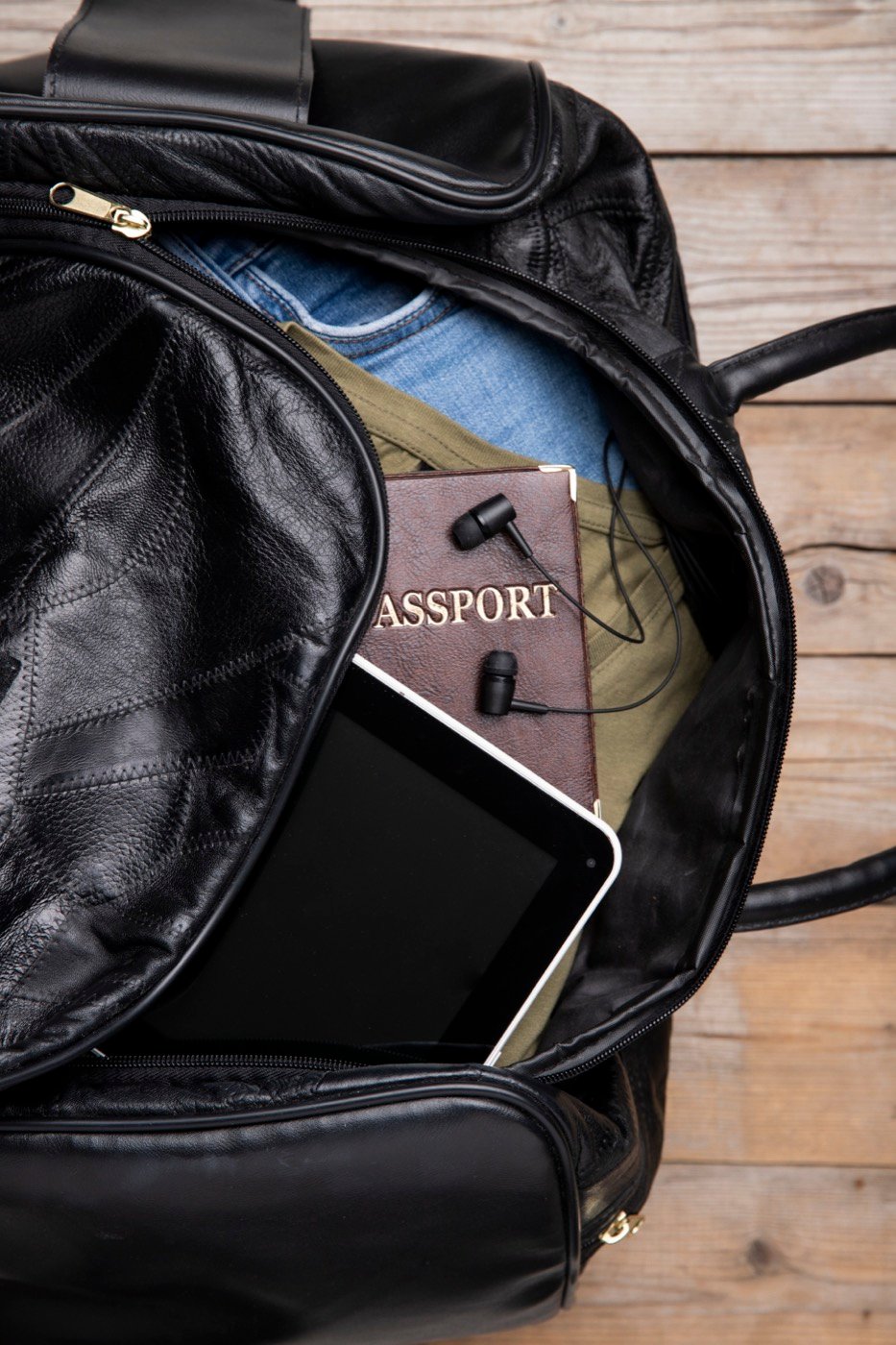A travel bag with earphones and a passport