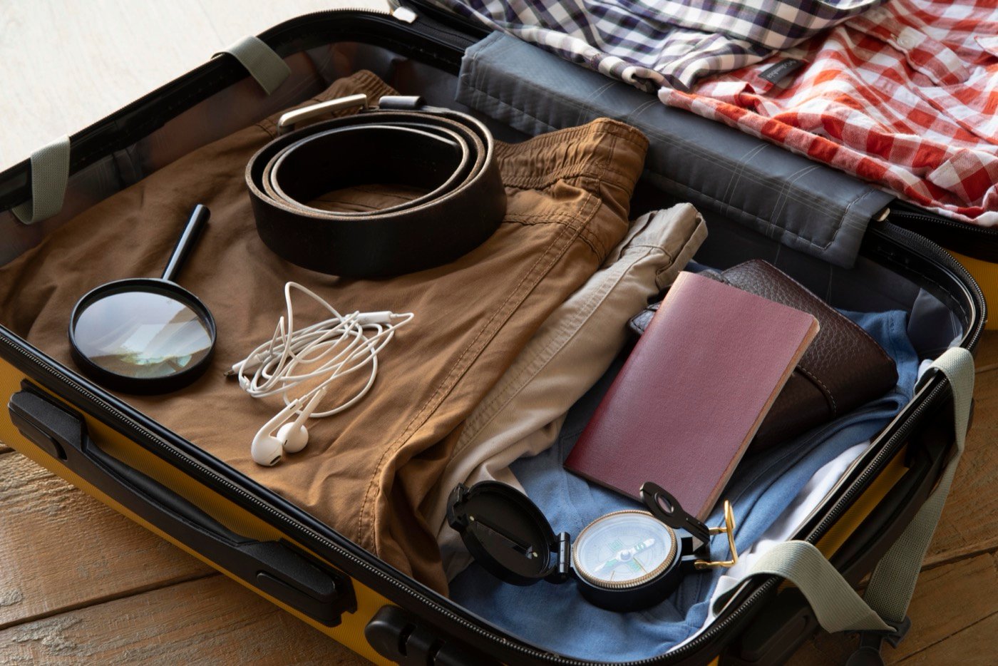 A travel suitcase laid out with packing essentials