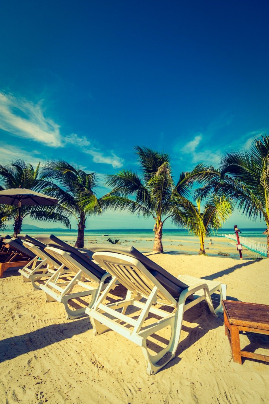 A beach umbrella and chair facing the sea